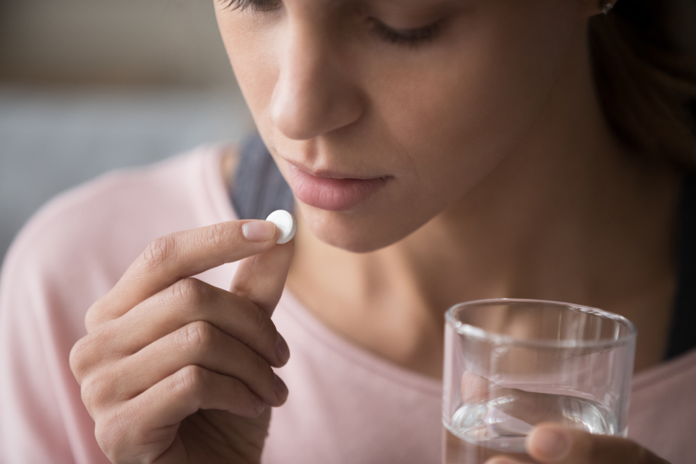 薬を飲む女性